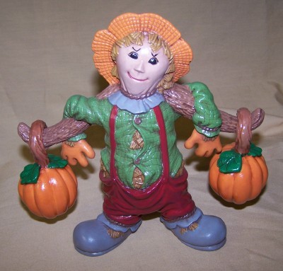 scarecrow carrying 2 pumpkins